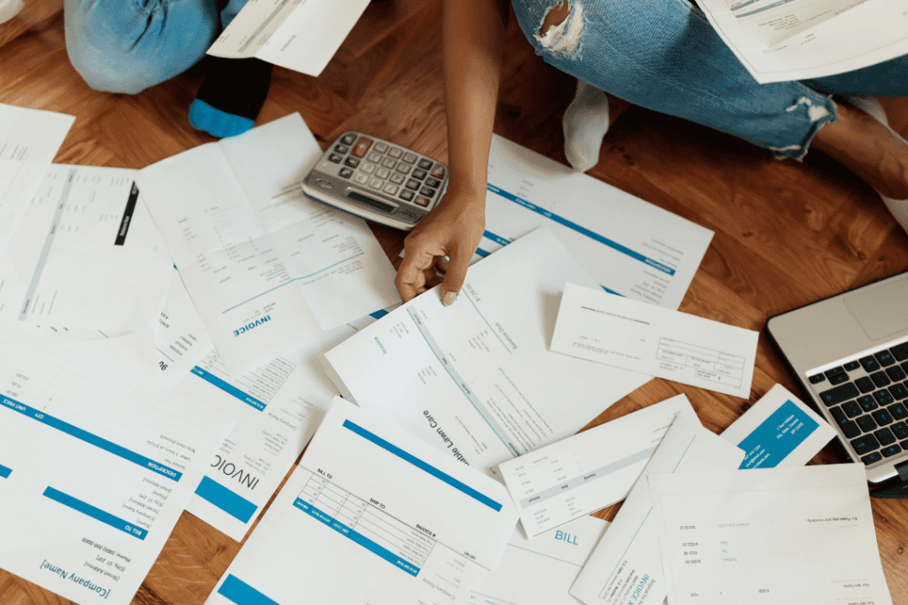 Couple going through stacks of bills and debts to figure out their TDSR for their home loan in Singapore