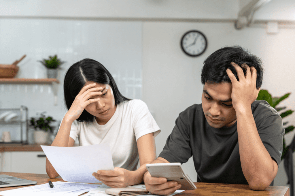 Couple looking through and calculating their total debts for their home loan in Singapore